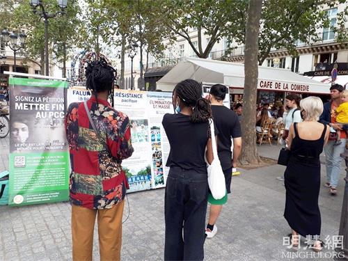 '圖4：巴黎民眾在柯萊特廣場觀看展板，了解法輪功真相。'