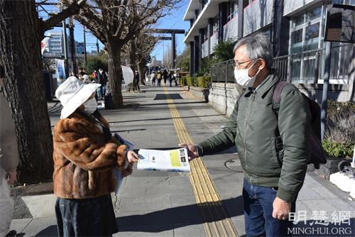 '圖1：二零二二年元旦，日本關東地區法輪功學員向過往的民眾發送真相資料。'