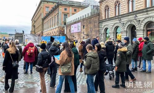 '圖1：二零二一年的十二月份，在斯德哥爾摩市中心國會大廈旁的錢幣廣場，每逢週末兩天，法輪功學員都會舉辦講真相活動。'