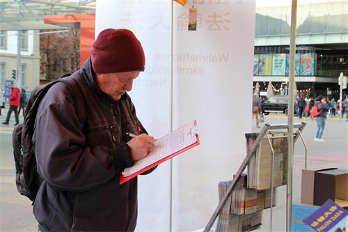 '圖3～8：二零二二年十一月五日和二十六日，法輪功學員在伯爾尼（Bern）市中心及火車站傳播真相和徵簽，過往行人簽名支持制止中共罪行。'
