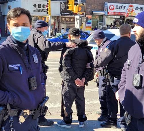'圖1：二月十五日中午時分，紐約市警109分局的警察在法拉盛緬街與凱辛娜大道的交界處，拘捕了近日來，多次暴力襲擊法輪功多個真相點的疑犯。（法輪功學員提供）'