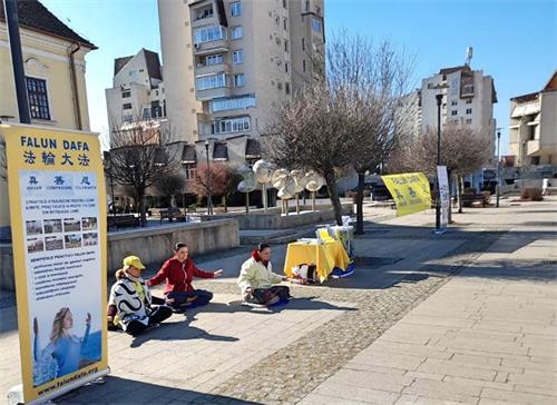 圖1-2：二零二二年三月十一日和十二日，法輪大法學員在特爾古穆列什（Târgu Mureş）市中心的玫瑰廣場向人們介紹法輪功。圖中的法輪功學員正在演示法輪功的第五套功法。