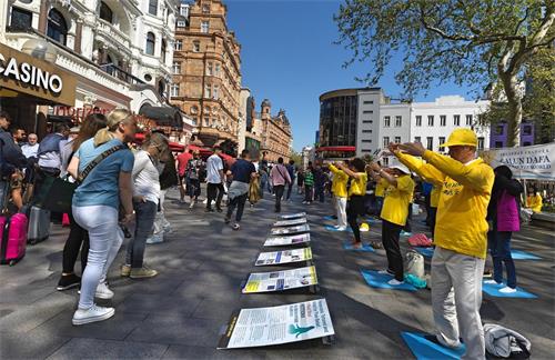 圖1～3：二零二二年四月十六日，英國法輪功學員在倫敦聖馬丁廣場展示功法，傳播法輪功的真相。