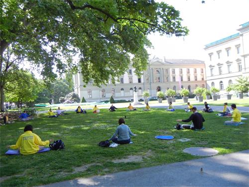 '圖1：二零二二年五月十四日，瑞士法語區的部份法輪功學員在日內瓦的公園展示法輪功功法。'