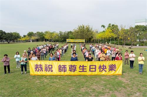 '圖1: 屏東部份法輪功學員齊聚千禧公園，雙手合十齊聲恭祝師父生日快樂。'