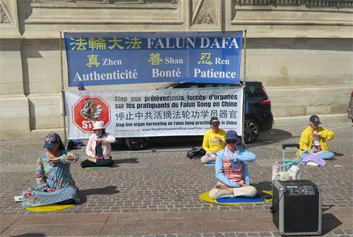 圖1：二零二二年六月十一日， 法輪功學員在巴黎市中心的夏特蕾街區演示法輪功功法。