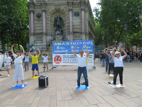 圖4：二零二二年六月十九日，法輪功學員在巴黎聖米歇爾廣場（Place Saint-Michel）演示法輪功功法。