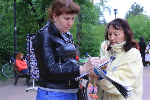'圖2～5：法輪功學員們向來參加安加爾斯克市城市日慶祝活動的人們講述法輪功的真相，並徵集簽名。了解真相的人們紛紛在徵簽表上簽名。'