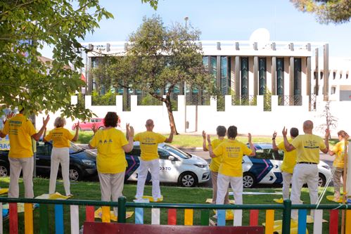 '圖6～9：西班牙法輪功學員中使館前舉辦反迫害二十三年集會。圖中學員在演示法輪功功法。'