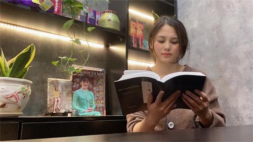 圖1：越南河內的美髮店老闆陳寶貸（Bao Loan）女士在看越南文版《轉法輪》