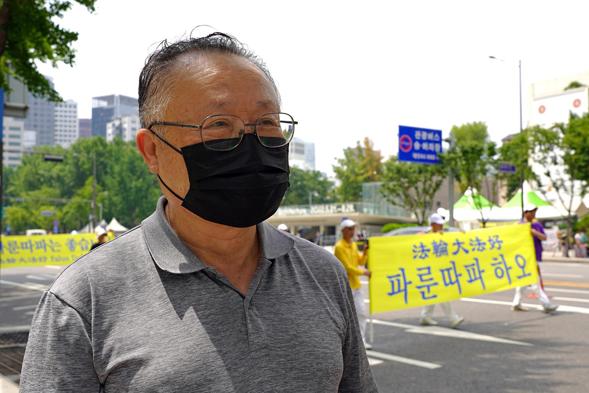 圖22：在街頭觀看法輪功遊行隊伍的首爾市民金在正先生支持反迫害，並希望法輪功廣傳世界。