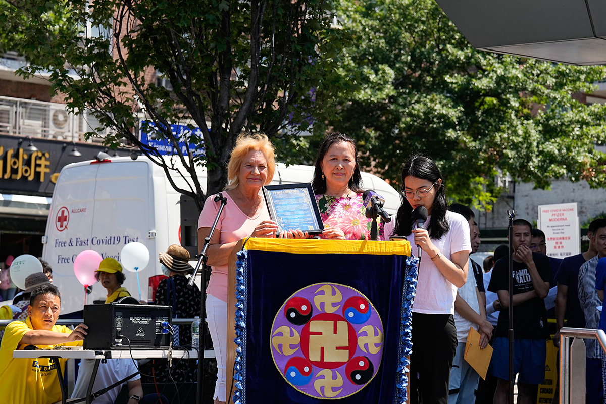 圖9：社區領袖瑪莎（左）在集會上，為全球退黨服務中心頒獎。