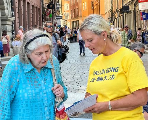 '圖2：二零二二年七月二十日，卡特琳在斯德哥爾摩參加法輪功和平反迫害二十三週年的活動中，向瑞典民眾面對面講真相。'