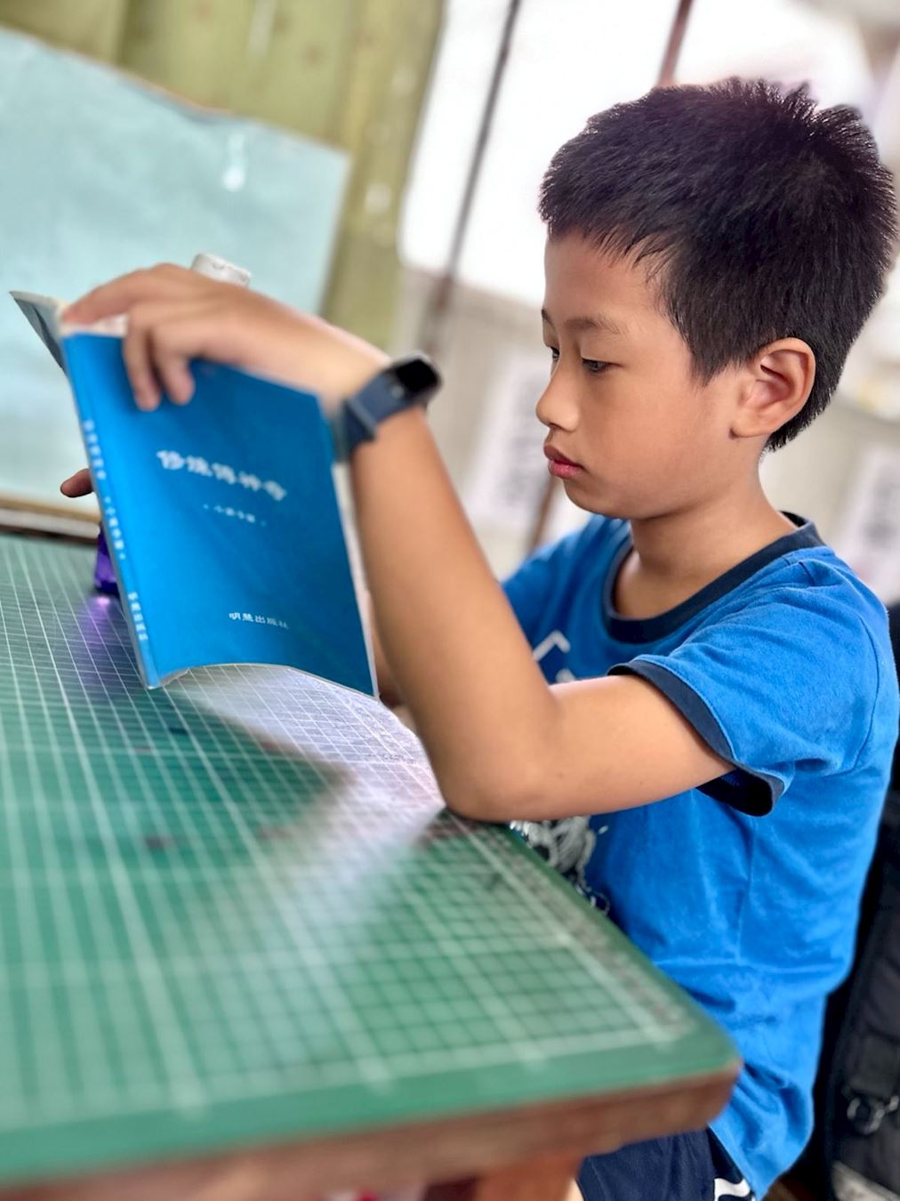 '圖3：台灣學生小毅閱讀明慧兒童故事集《修煉傳神奇》'