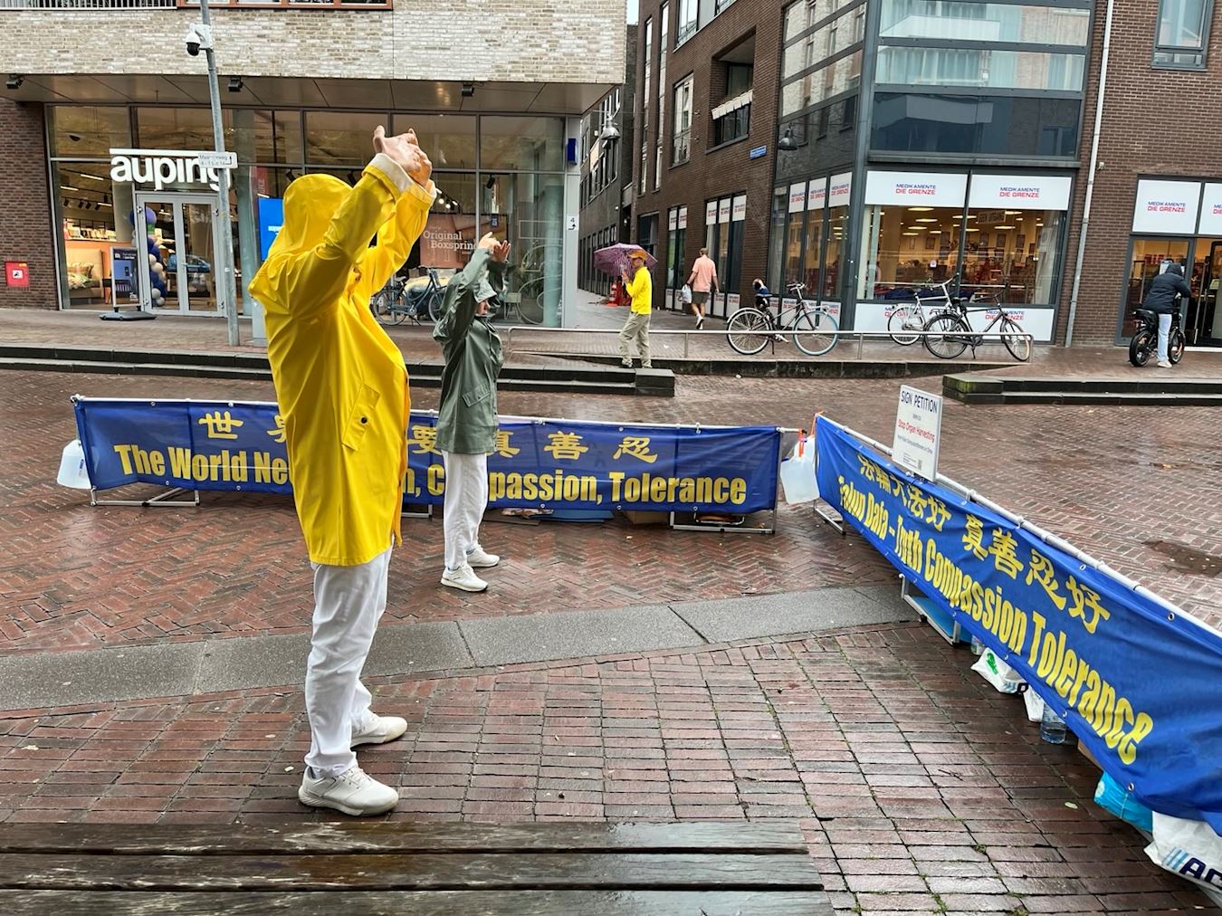 '圖1~3:二零二五年九月二十日,法輪功學員在埃德(Ede)市舉辦信息日活動,在火車站附近的街道布置展板,展示法輪功功法,傳播法輪功真相。'